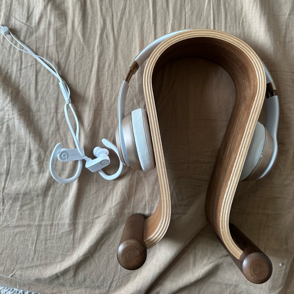 Two pairs of wireless headphones and headphone stand